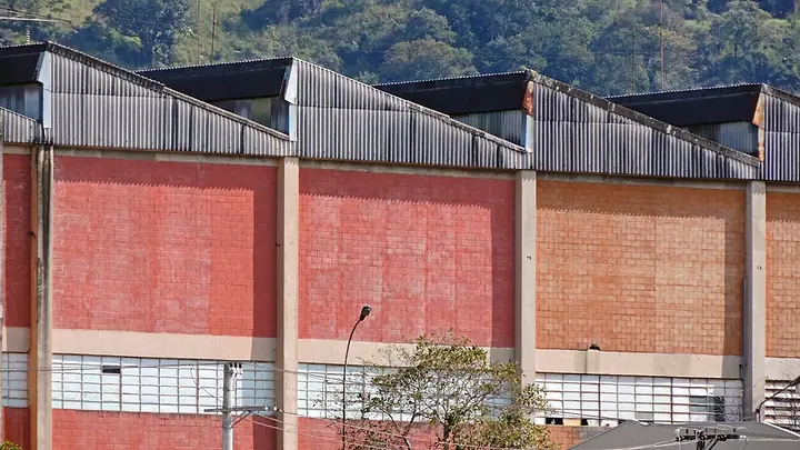 Galpões industriais de tijolo com telhado em serra